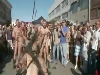 Offentlig plaza med avskalade män prepared för vild coarse violent bög grupp smutsiga video- show